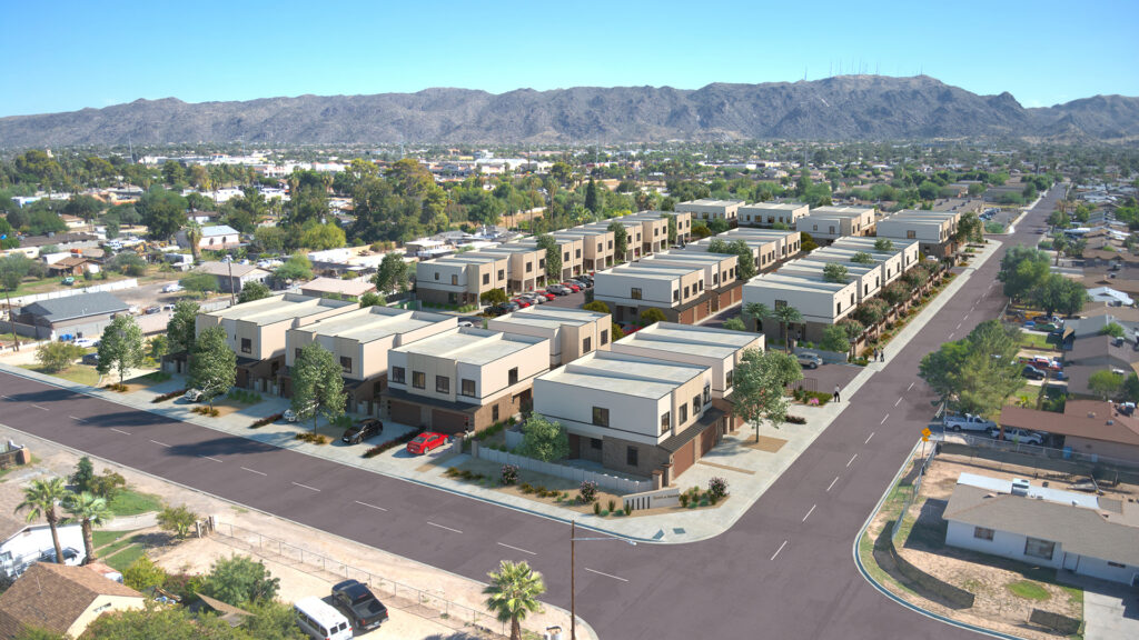 Aerial view of a modern residential complex with uniform two-story homes, surrounded by palm trees, streets, and a mountainous backdrop that elevates the scenery to new heights.